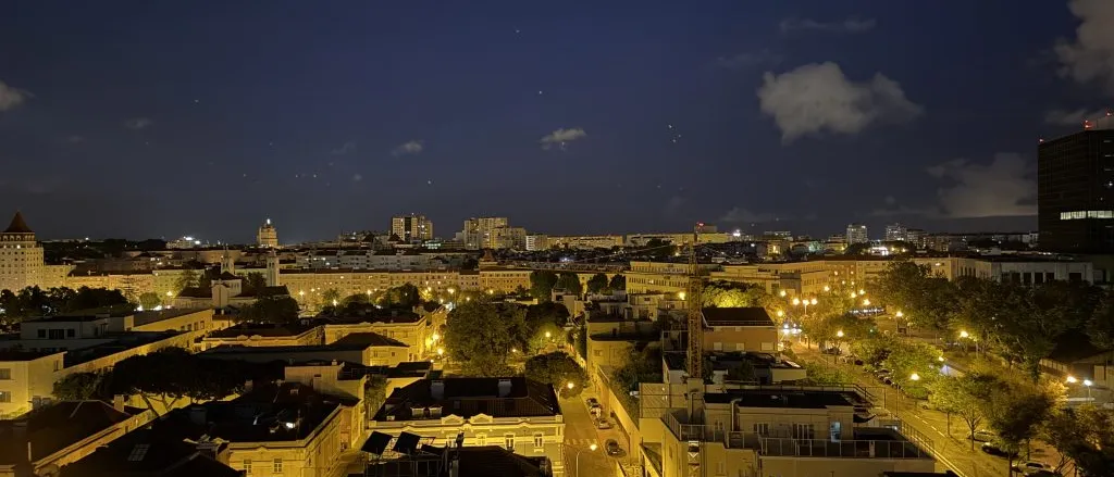 A photo of the Lisbon, Portugal skyline at night. Lights glowing below in the city quiet city streets