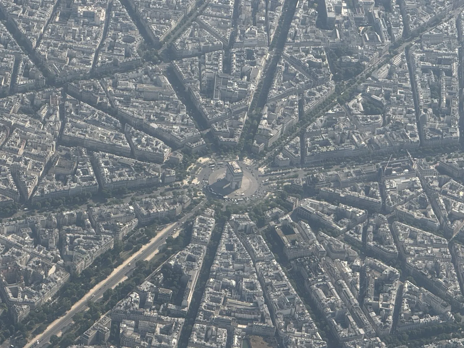 An aerial view of a city with a triumphal arch at the centre of a star of radiating avenues